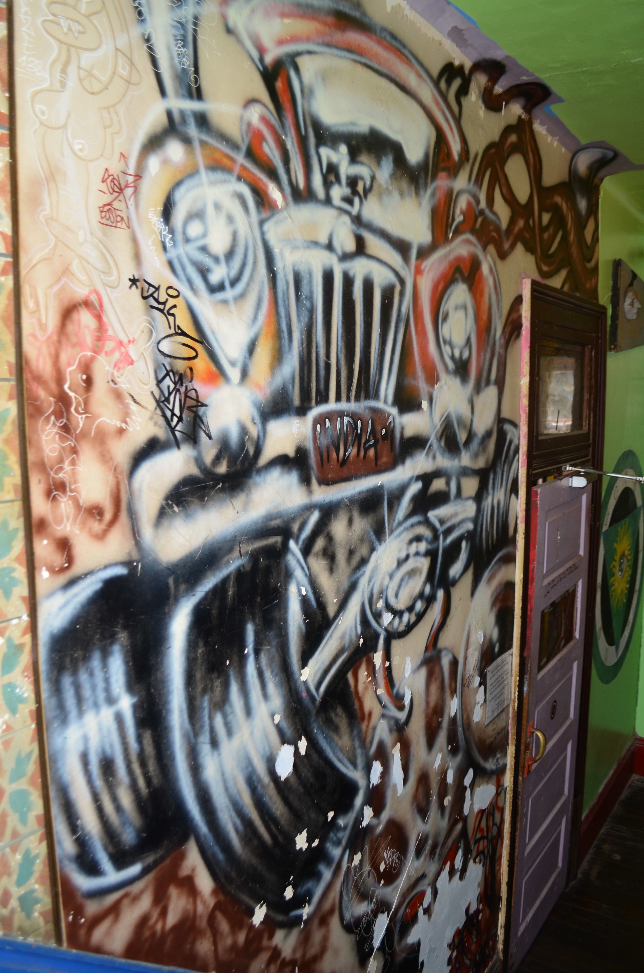 A wall with graffiti and a door with a lock.