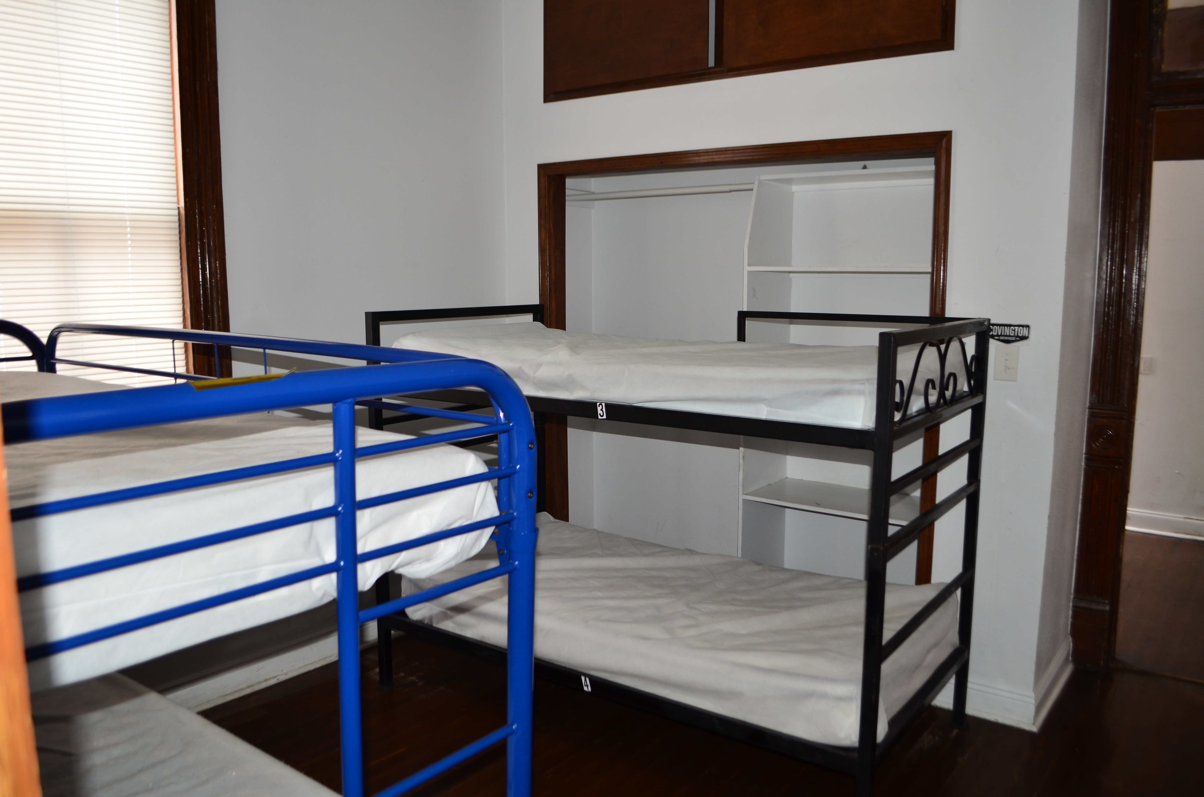A bunk bed room with a wooden headboard and a small shelf.
