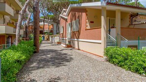 A pathway leading to a building with a brick facade and a covered porch. - Apartment Ancora on the sea (Marina di Grosseto)