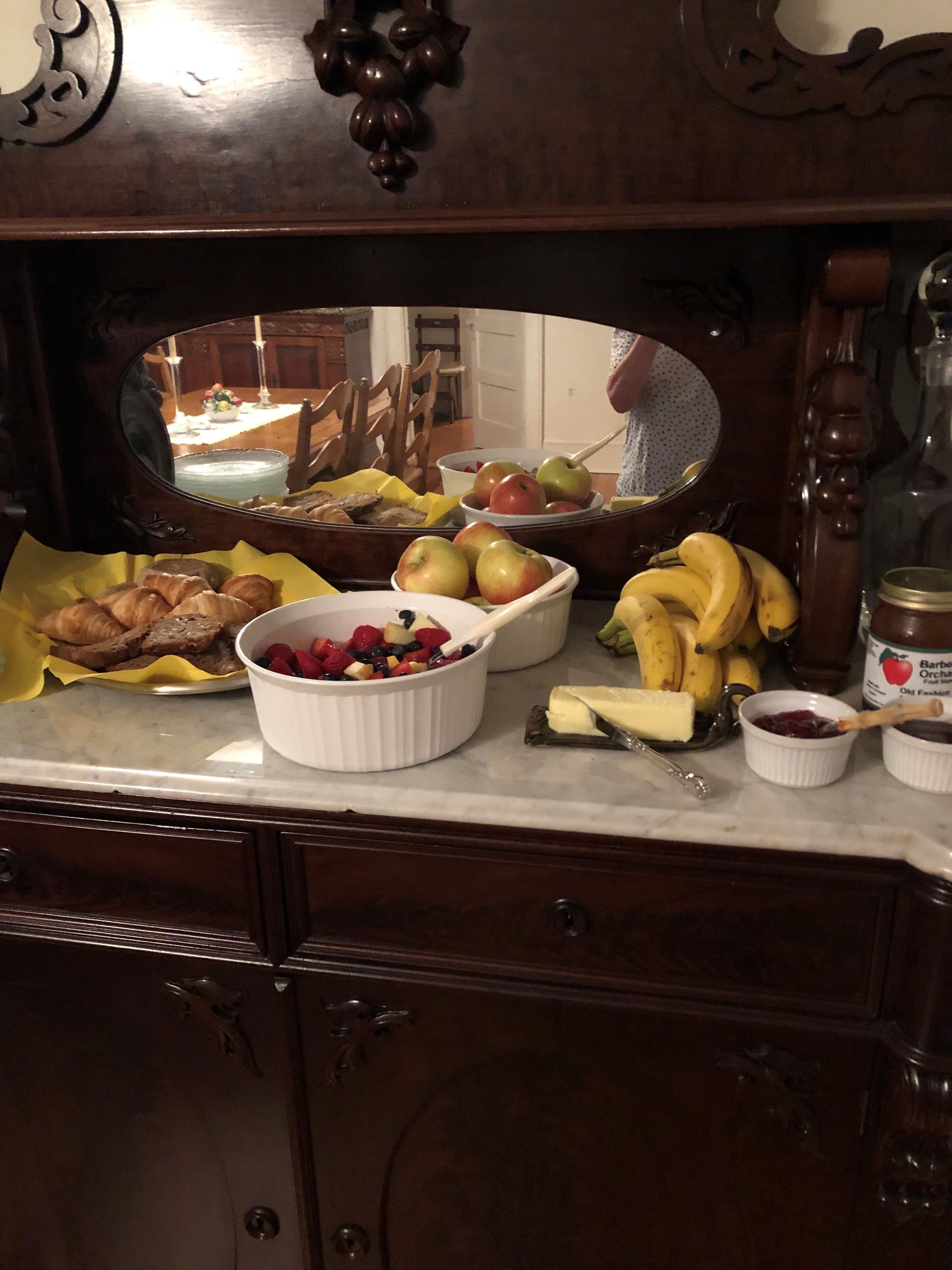 Een keukentafel met verschillende etenswaren, zoals fruit, groenten en kruiden.