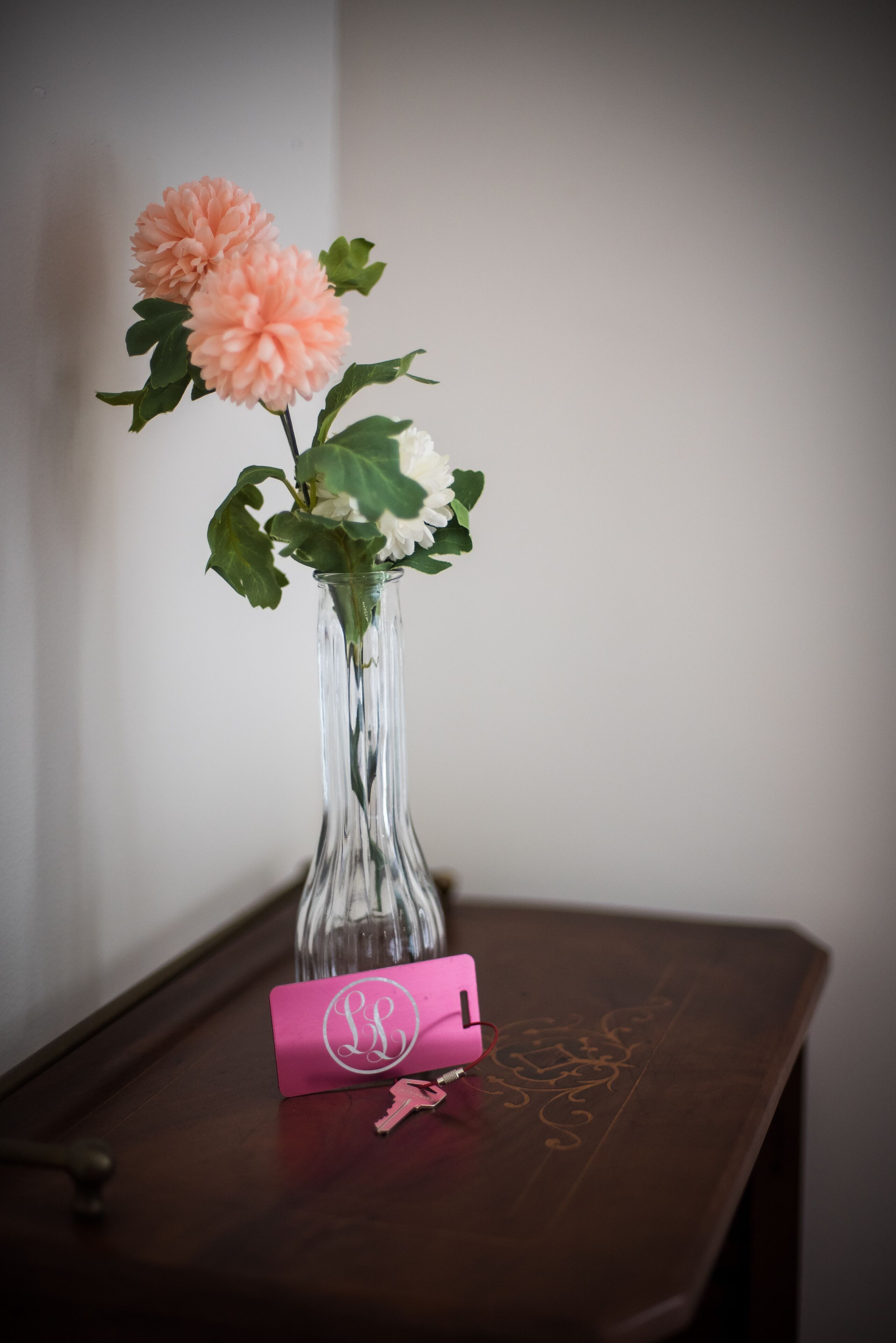 A clear glass vase with flowers on a wooden table.