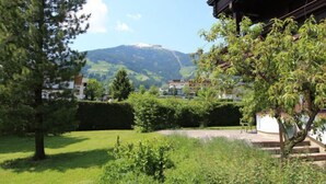 A residential area with a view of a mountain, a well-maintained lawn, and a building with a traditional architectural style. - Römerhof by Interhome (Fügen)