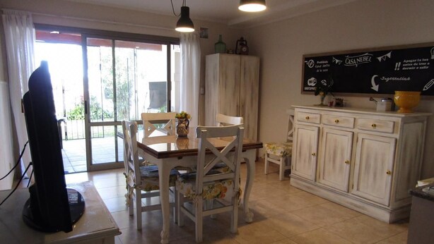 A dining area with a table, chairs, and a cabinet. - Casa Nebel - Duplex (Concordia)