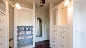 A hallway with a white door, a mirror, and a metal storage unit.