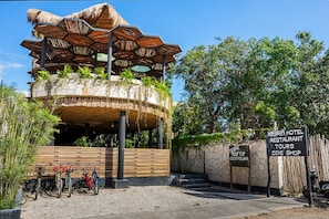 A building with a unique hexagonal roof structure, a rooftop bar, and a sign indicating a dive shop. - Maka Hotel Boutique (Tulum)