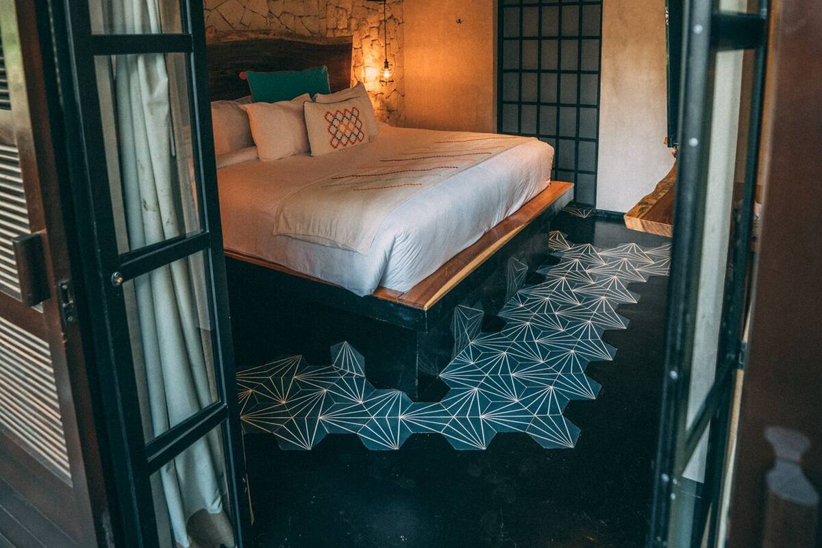 Ein Schlafzimmer mit Bett, Deckenventilator, Fenster und Tür.