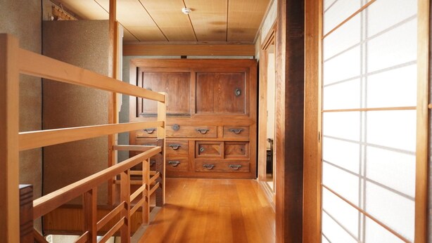 A traditional Japanese interior with wooden flooring, sliding doors, and a built-in cabinet with drawers. - Private House for Rabbit Island (Takehara)