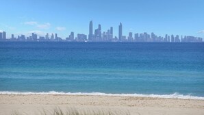Una playa con un horizonte urbano al fondo.