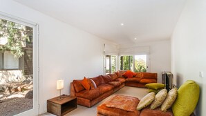 A spacious living room with a large sectional sofa, a small side table, and a television. - Breaker Eight (Lorne)