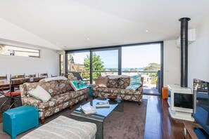 Ein modernes Wohnzimmer mit großem Fenster, Kamin und Essbereich.