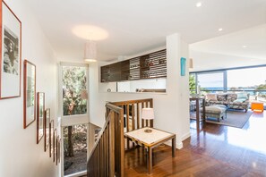 A modern interior with a staircase, wooden flooring, and a view to the outside.