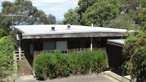 A building with a flat roof, a visible number '49', and a paved driveway leading to the entrance.
