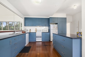 Eine moderne Küche mit blauen Schränken, einem weißen Herd und einem Kühlschrank.