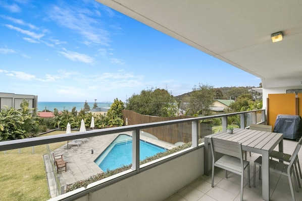 A balcony with a view of the sea, a pool, and outdoor furniture. - Lorne Chalet Apartment 29 (Lorne)