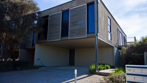 A modern two-story building with a flat roof and large windows. - Debonair 1 (Anglesea)