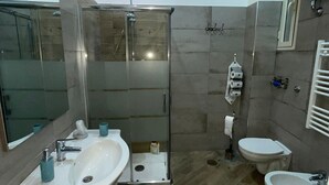 A modern bathroom with a glass-enclosed shower, a double sink, a toilet, and a bidet. - Sleeping in Naples Center holiday house holiday home (Napoli)