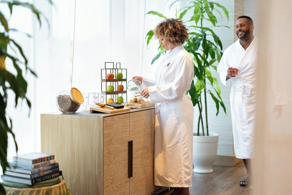 A person in a white robe preparing food at a wooden counter with a fruit display and books. - JW Marriott Orlando Bonnet Creek Resort & Spa (Orlando)