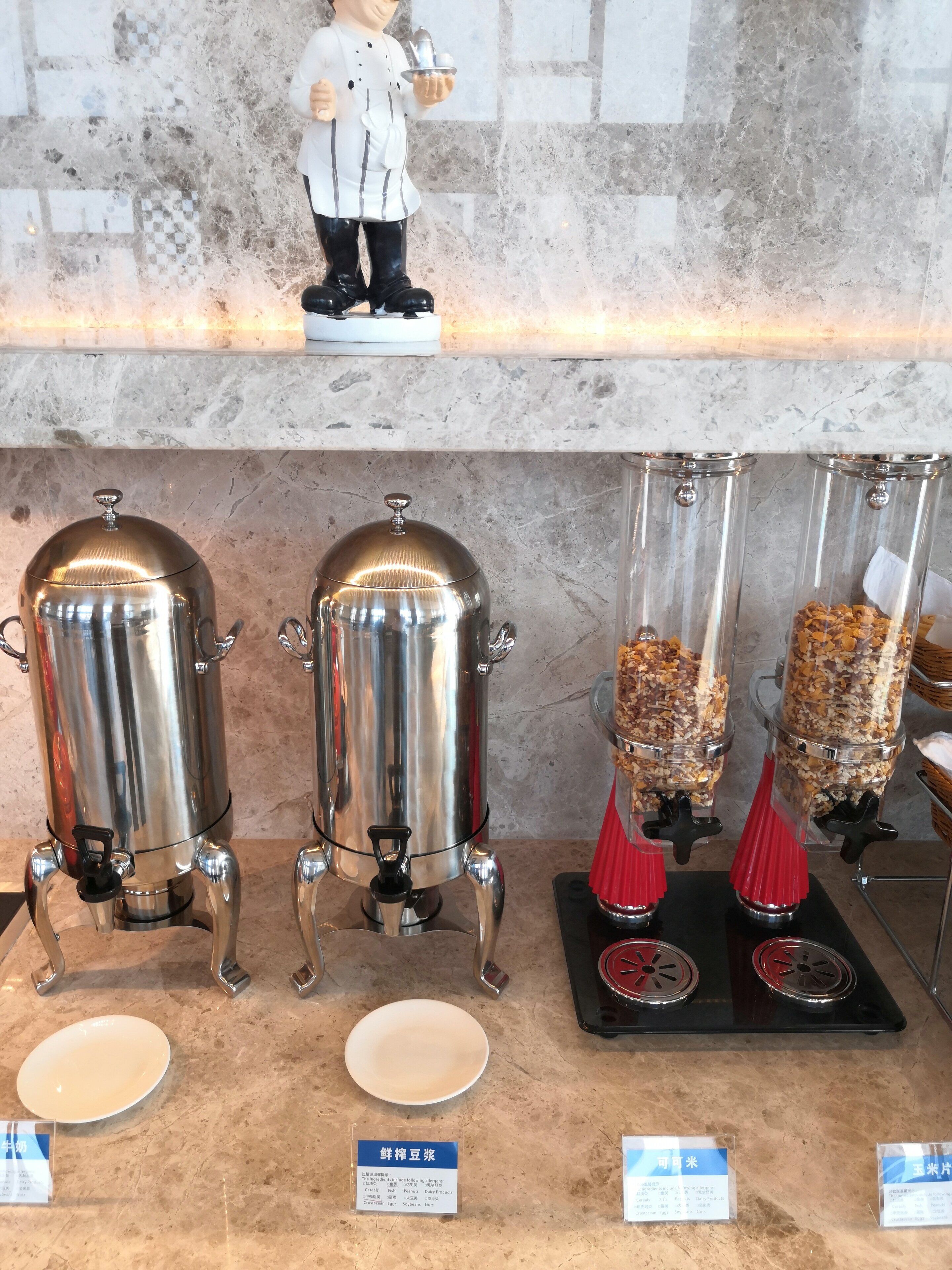 A coffee station with two espresso machines and two coffee dispensers, a ceramic plate, and a menu board.