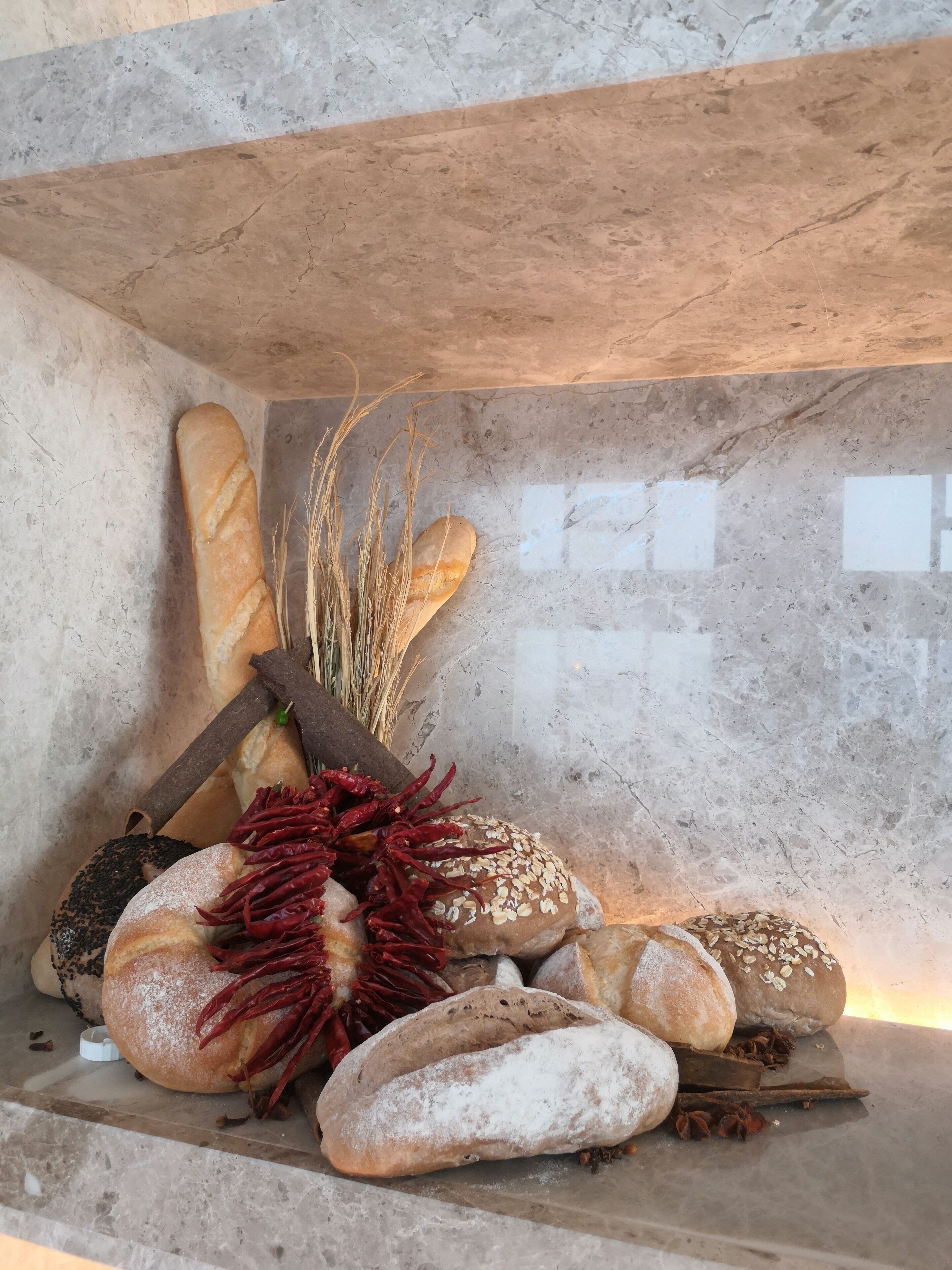 A variety of breads and pastries on a marble countertop.