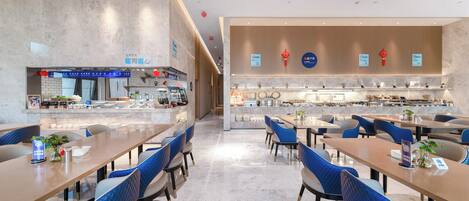 Un restaurante moderno con una barra central, sillas tapizadas en azul y un diseño limpio y contemporáneo.