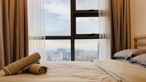 A hotel room with a large window, a bed with a rolled towel, and a city view. - Cozy Room 500m LRT/MRT KLCC Pavilion Chinatown (Bukit Bintang)