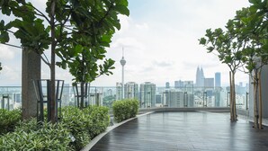 A rooftop terrace with a city skyline view, including a tower and skyscrapers. - Cozy Room 500m LRT/MRT KLCC Pavilion Chinatown (Bukit Bintang)
