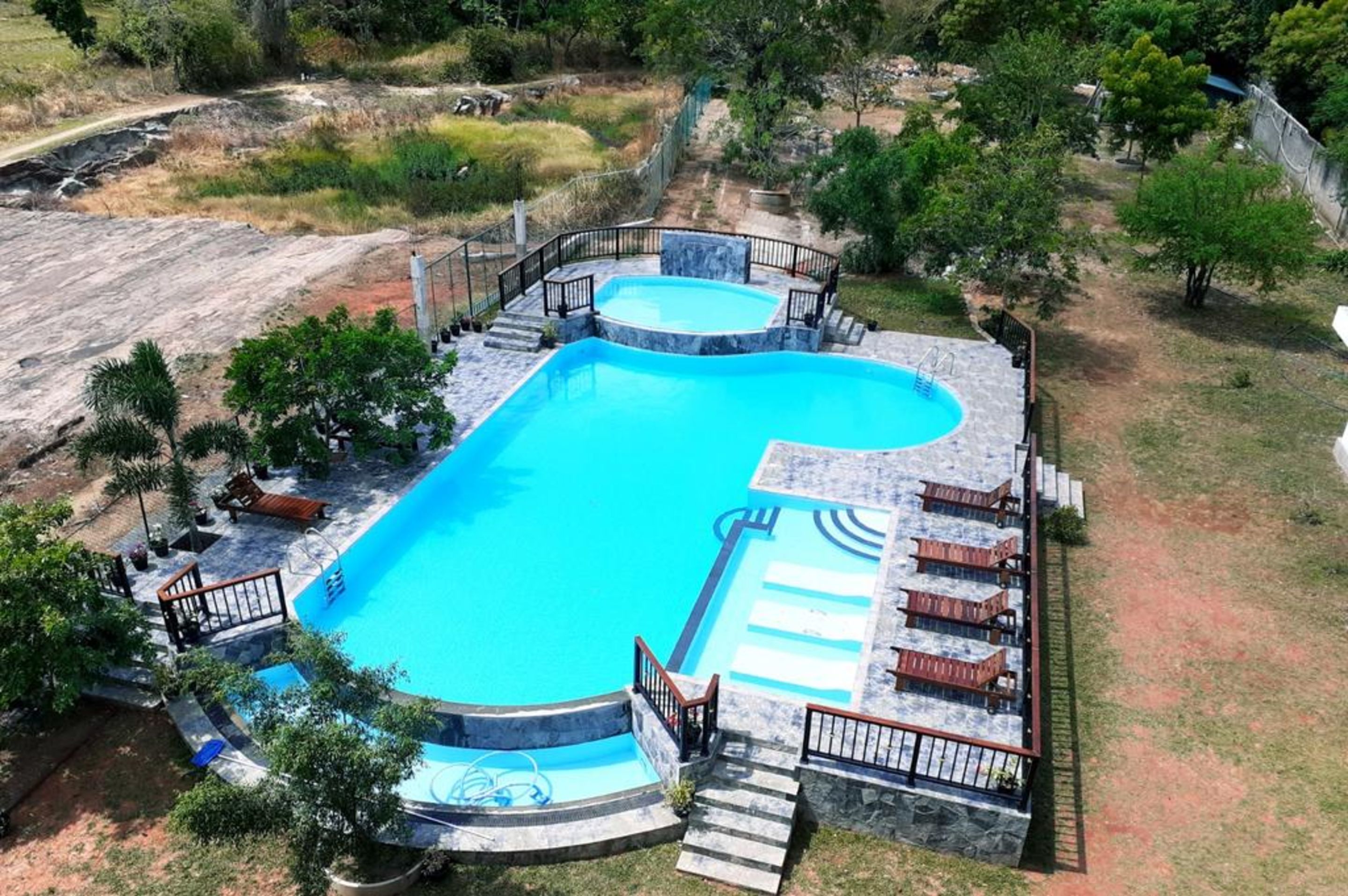 Una piscina al aire libre, sillones reclinables de piscina