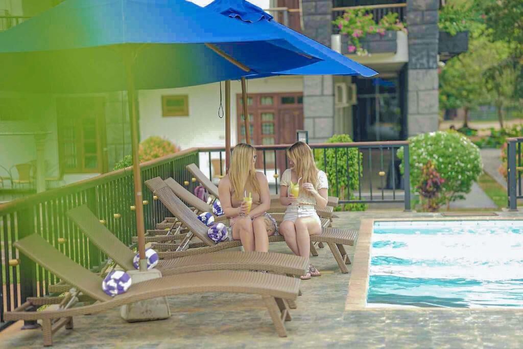 A poolside area with lounge chairs and a blue umbrella.