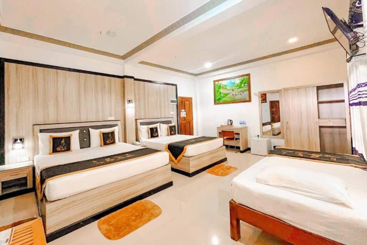 Quarto de hotel com duas camas, uma escrivaninha, uma cadeira, uma televisão e um quadro na parede.