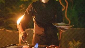Une personne qui fait griller des aliments sur un barbecue à l’extérieur, la nuit.