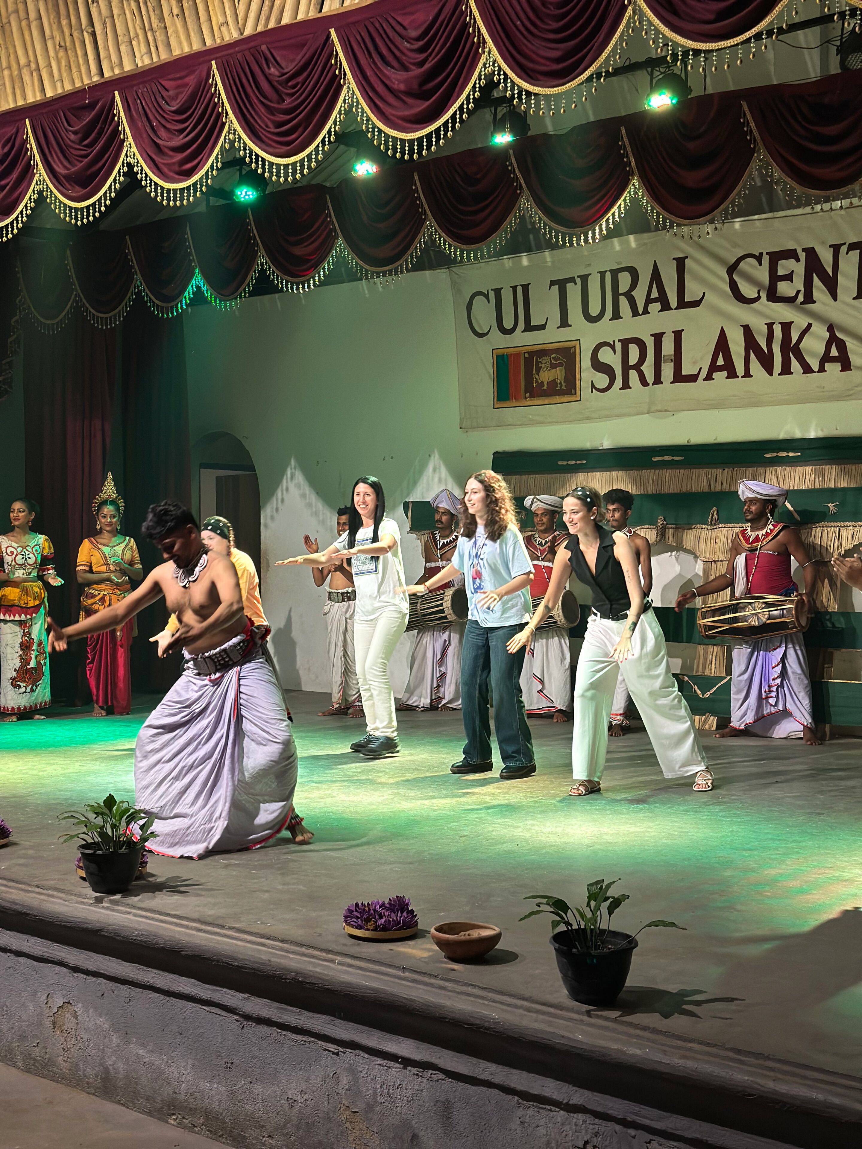 Un escenario de centro cultural con artistas vestidos con trajes tradicionales.