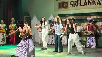 Un escenario de centro cultural con artistas vestidos con trajes tradicionales.