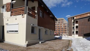 Ein Gebäude mit einem courtyard aus Ziegelpflaster, hölzernen Balkonen und einem mit Schnee bedeckten Platz.