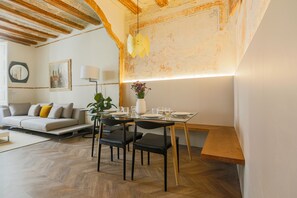 Un salon moderne avec un canapé, une table à manger, des chaises et une plante.