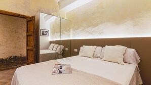 Ein Hotelzimmer mit einem großen Bett, einem Holzschrank und einem Spiegel an der Wand.