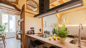 Eine moderne Küche mit einer zentralen Kochinsel, Barhocker, einer Spüle und einem Blumentopf.