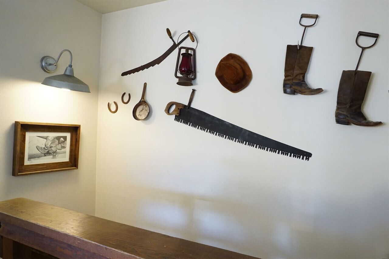 A wall with various tools and a framed picture.