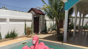 A swimming pool with a pink flamingo float.