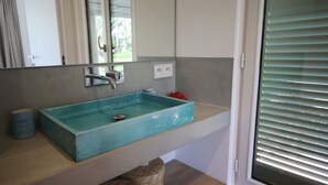 A bathroom with a turquoise sink, a mirror, and a window with blinds. - Unique: magnificent villa in Porquerolles (Ile de Porquerolles)