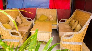 A wicker furniture set with cushions, a small table, and a red and blue backdrop.