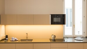 A modern kitchen with a microwave, kettle, and tea set on the counter. - Amazing Piazza Venezia Suite Int 20 (Roma)
