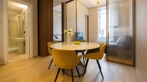 A modern dining area with a round table, yellow chairs, and a vase with flowers. - Amazing Piazza Venezia Suite Int 20 (Roma)