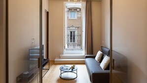 A modern living room with a sofa, a coffee table, and a TV. - Amazing Piazza Venezia Suite Int 20 (Roma)