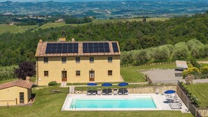 Un bâtiment doté de panneaux solaires, d’une piscine et offrant une vue sur la campagne.