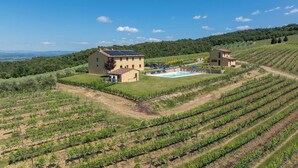 Un domaine viticole doté d’une piscine, de deux bâtiments principaux et de terrasses où sont cultivées les vignes.