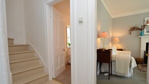 A staircase leading to a bedroom with a bed, bedside lamps, and a fireplace. - Garden cottage, estate property set in amazing gardens, pet friendly, Wi-Fi (Strachur)