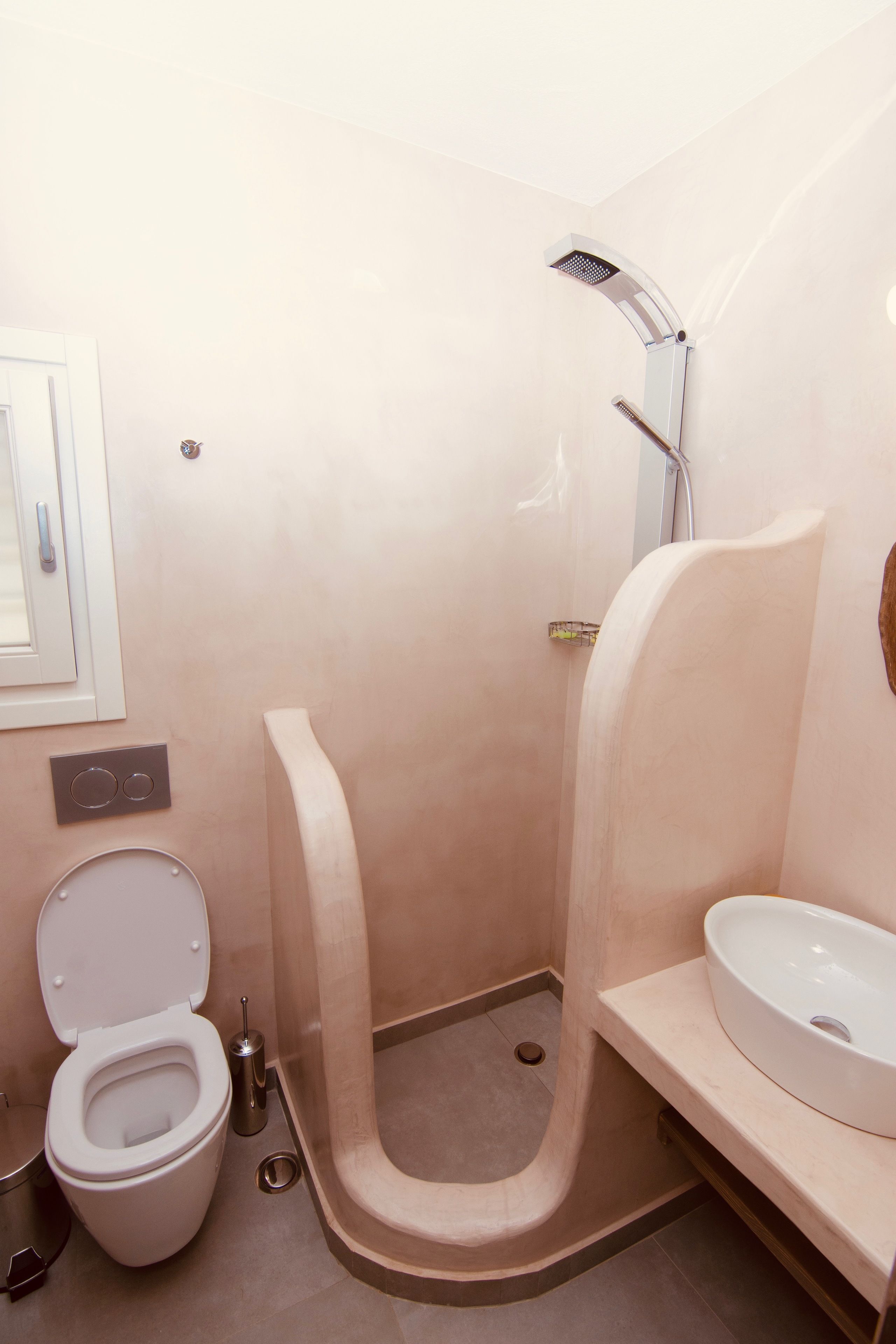 A modern bathroom with a toilet, a sink, and a shower.