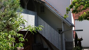 A building with a steeply pitched roof, a visible clock, and a small window.