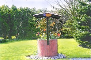 Surrounded by lush greenery, this garden feature offers a serene retreat.