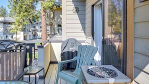 Un balcone con mobili da esterno, un barbecue e un braciere decorativo.